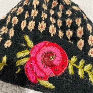 Wool knit beanie with red accent flower
